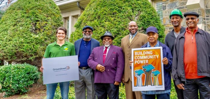 Groundswell members holding community power sign